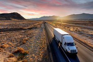 White Semi-Trailer Truck Heading down a four-lane Highway at Dusk delivering a load in the southeastern Utah desert on interstate 70 east bound