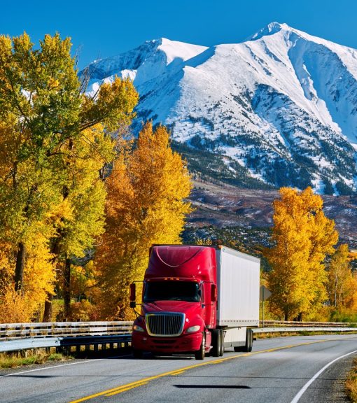 Red truck on highway in Colorado at autumn, USA. Mount Sopris landscape.